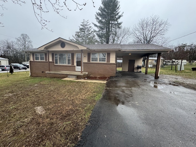 view of front of home with a front yard and a carport