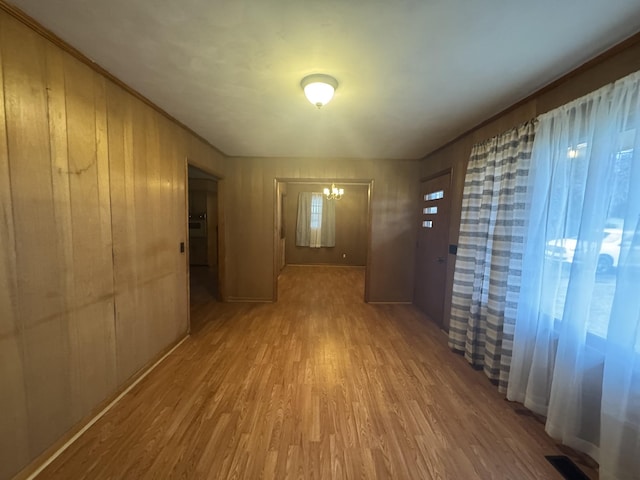 hallway with a chandelier and light hardwood / wood-style floors