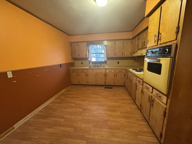 kitchen featuring sink, white electric cooktop, light brown cabinetry, oven, and light wood-type flooring