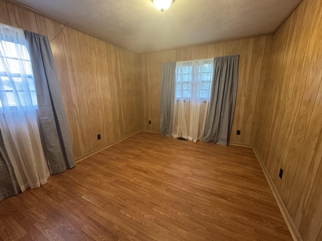 spare room featuring hardwood / wood-style floors and wood walls