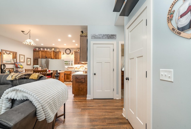 bedroom featuring stainless steel fridge and dark hardwood / wood-style flooring