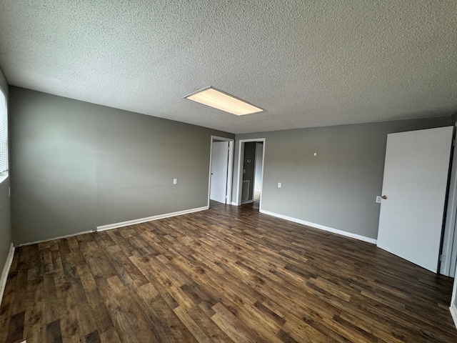 unfurnished room featuring dark hardwood / wood-style flooring and a textured ceiling