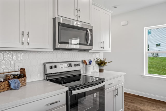 kitchen with white cabinetry, appliances with stainless steel finishes, dark hardwood / wood-style floors, and backsplash