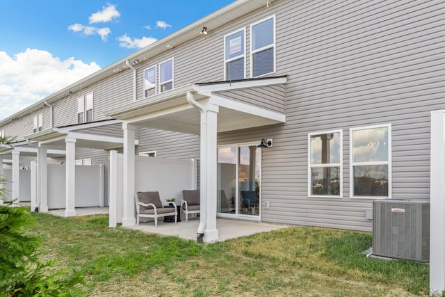 back of property with a yard, central AC unit, and a patio area