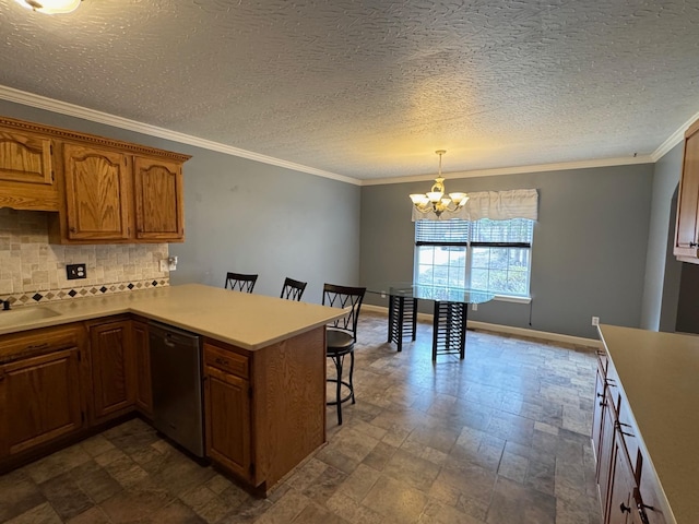 kitchen featuring crown molding, dishwasher, a breakfast bar area, light countertops, and decorative backsplash