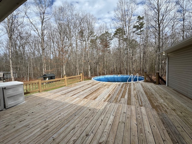 wooden deck featuring a grill and an outdoor pool