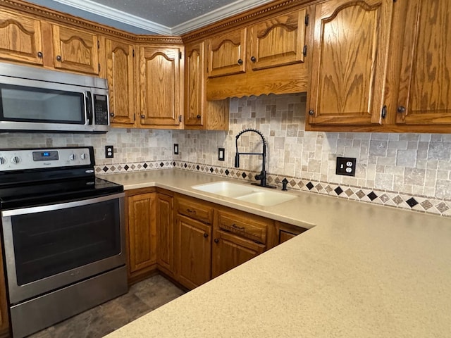 kitchen featuring brown cabinetry, a sink, light countertops, appliances with stainless steel finishes, and tasteful backsplash