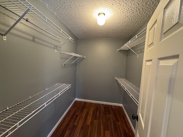 walk in closet with wood finished floors