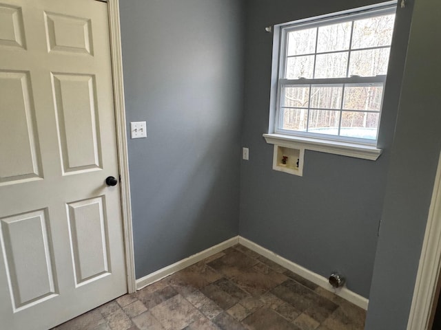 laundry area with baseboards, washer hookup, laundry area, and stone finish floor