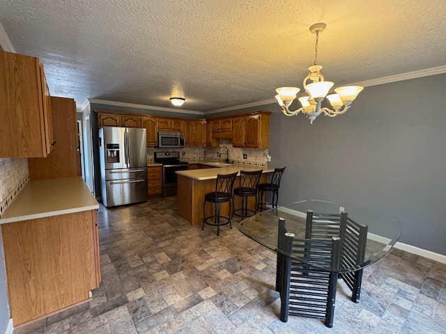 kitchen with brown cabinets, backsplash, stainless steel appliances, a peninsula, and baseboards