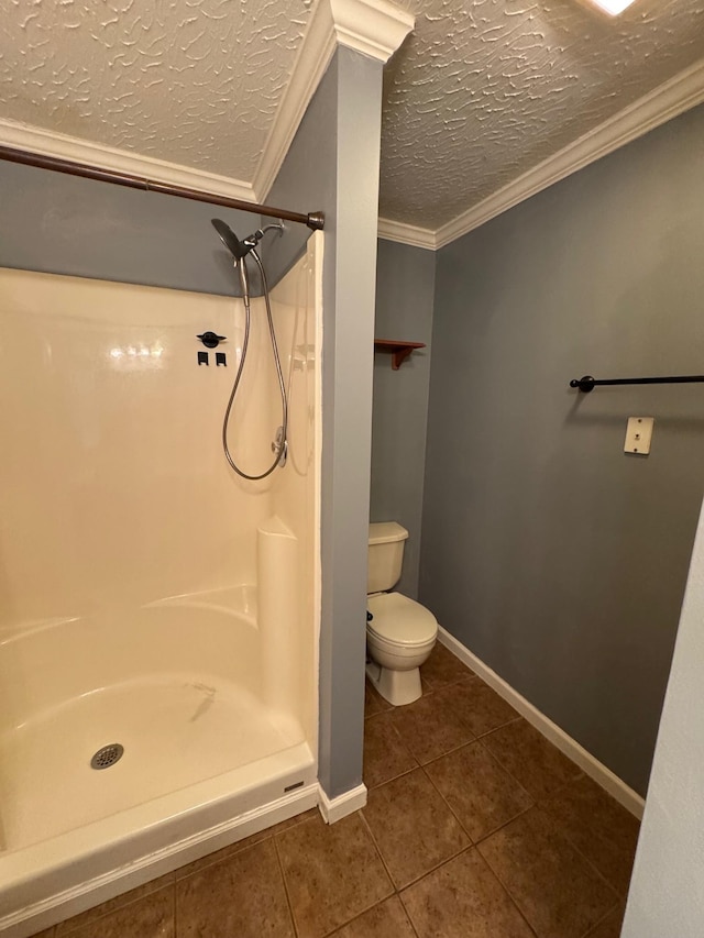 bathroom with a textured ceiling, toilet, a stall shower, and ornamental molding