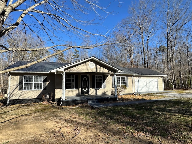 view of front of house with a garage, covered porch, and driveway