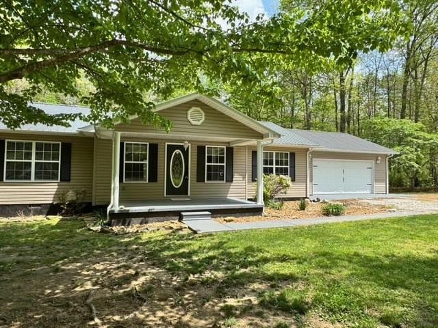238 Laurens Ln, Grimsley, TN 38565 - single story home with a porch, an attached garage, driveway, and a front lawn