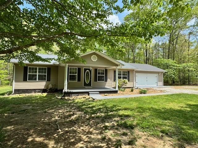 238 Laurens Ln, Grimsley, TN 38565 - ranch-style home with a porch, a garage, driveway, and a front yard
