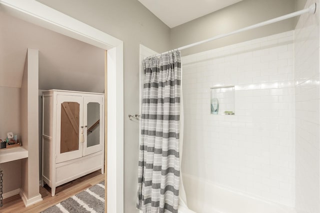 bathroom with hardwood / wood-style floors and shower / bath combo with shower curtain