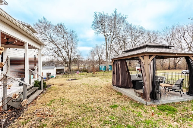 view of yard featuring a gazebo, ceiling fan, and an outbuilding