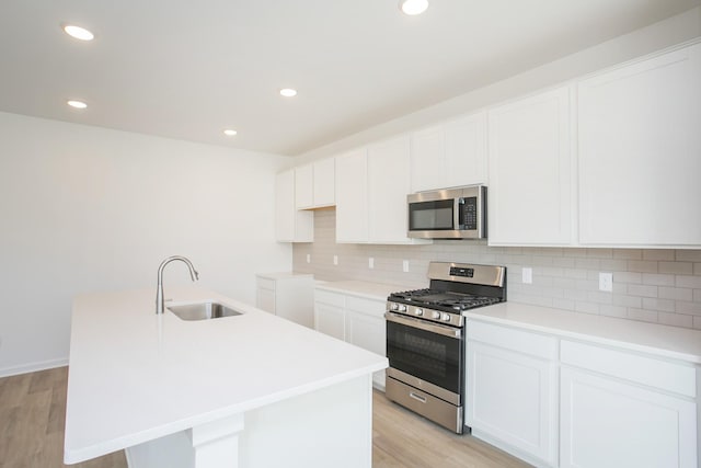 kitchen featuring white cabinetry, sink, an island with sink, and appliances with stainless steel finishes