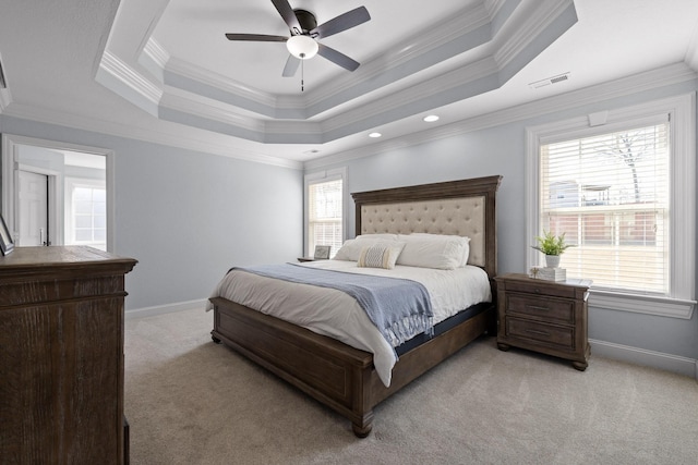 carpeted bedroom with a raised ceiling, crown molding, and ceiling fan