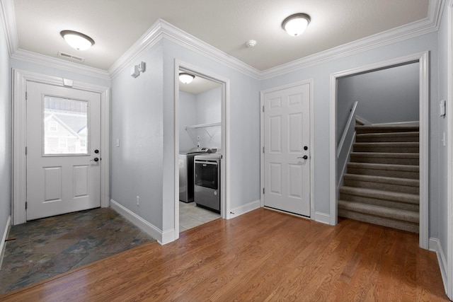 entrance foyer with washer / clothes dryer, ornamental molding, and light hardwood / wood-style flooring