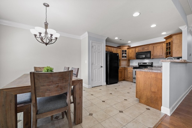 kitchen featuring pendant lighting, ornamental molding, black appliances, kitchen peninsula, and a chandelier