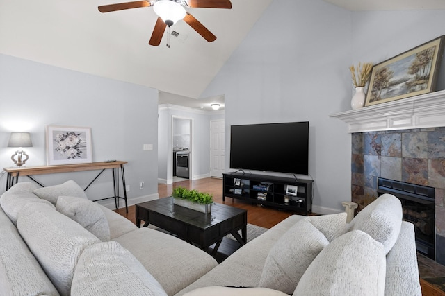 living room featuring hardwood / wood-style floors, a fireplace, high vaulted ceiling, and ceiling fan