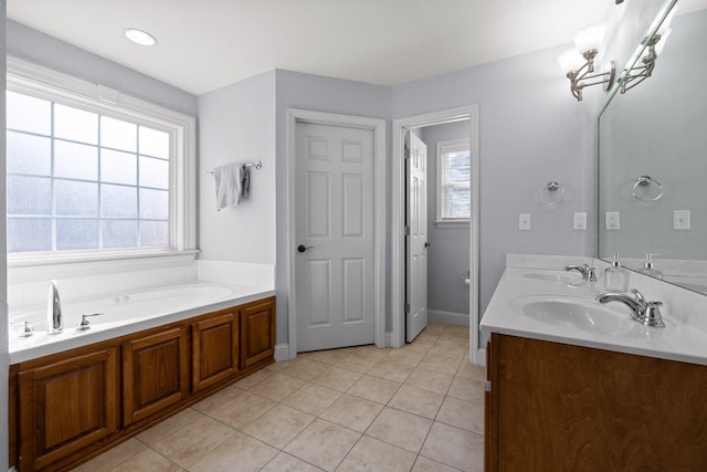 bathroom featuring vanity, a healthy amount of sunlight, tile patterned floors, and a tub to relax in