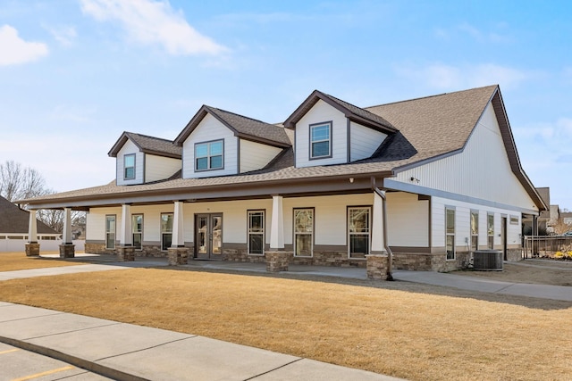 view of front facade featuring a front lawn, central air condition unit, and covered porch