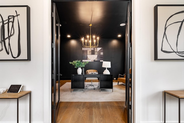 hallway with a chandelier and wood-type flooring