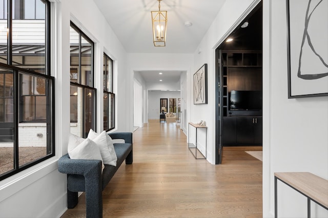 hall featuring light hardwood / wood-style floors and a chandelier