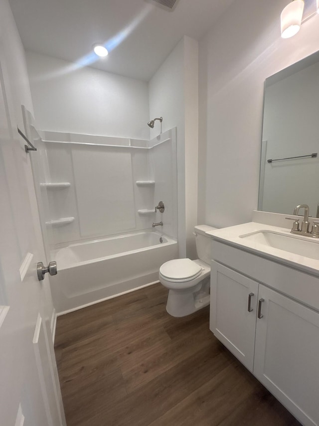 full bathroom featuring vanity, hardwood / wood-style flooring, bathing tub / shower combination, and toilet