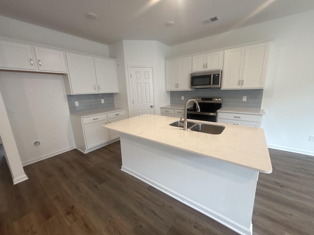 kitchen featuring stainless steel appliances, white cabinetry, dark hardwood / wood-style floors, and a center island with sink