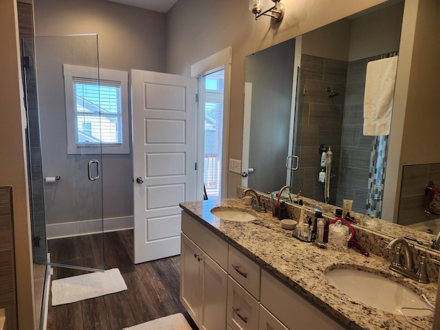 bathroom featuring vanity, hardwood / wood-style flooring, and a shower with door