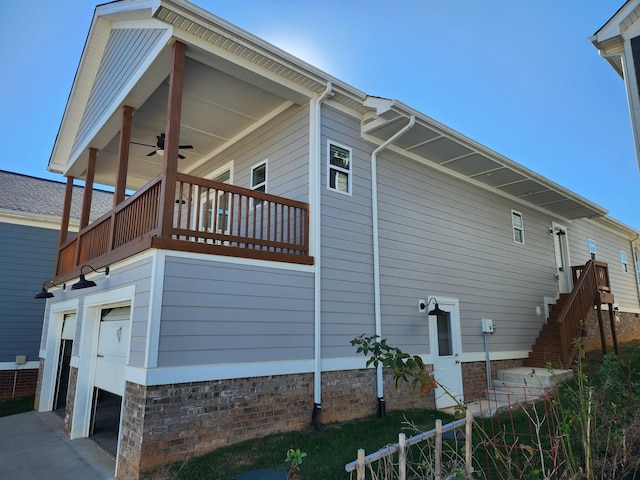 view of side of property with ceiling fan and a balcony