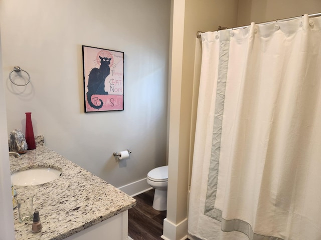 bathroom featuring vanity, hardwood / wood-style flooring, curtained shower, and toilet