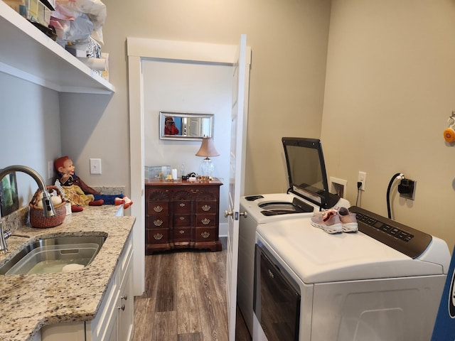 laundry area featuring cabinets, sink, dark wood-type flooring, and washer and clothes dryer