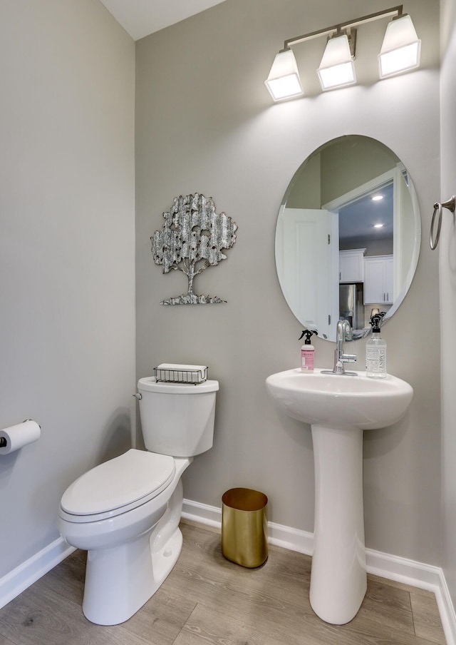 bathroom with wood-type flooring and toilet