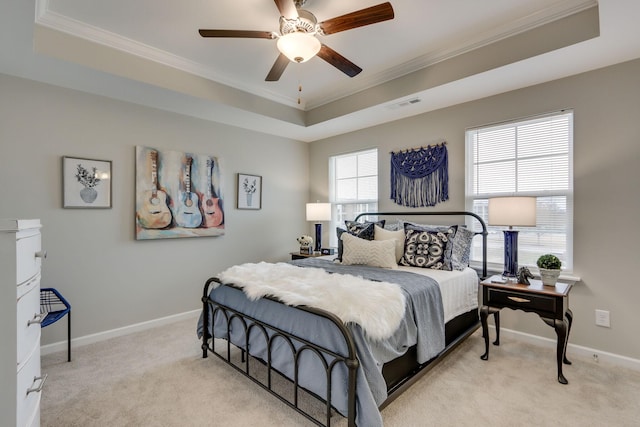 bedroom featuring crown molding, light colored carpet, a tray ceiling, and ceiling fan