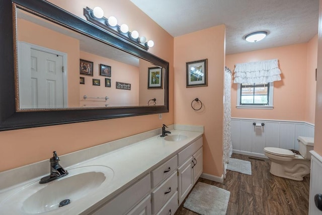 bathroom with vanity, hardwood / wood-style floors, a textured ceiling, and toilet