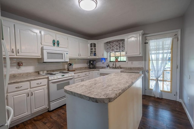 kitchen featuring white cabinetry, white appliances, dark hardwood / wood-style floors, and a center island