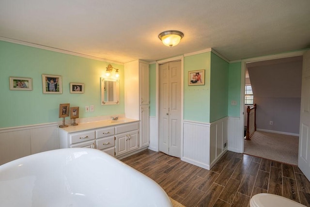 bathroom featuring crown molding, vanity, and a tub