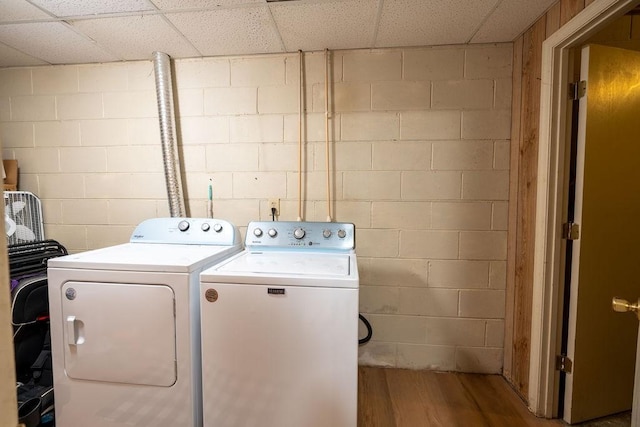 clothes washing area featuring washing machine and dryer and hardwood / wood-style floors