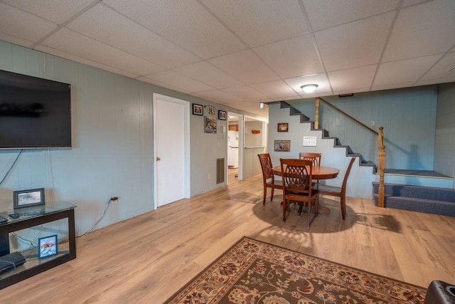 dining room with hardwood / wood-style floors and a drop ceiling