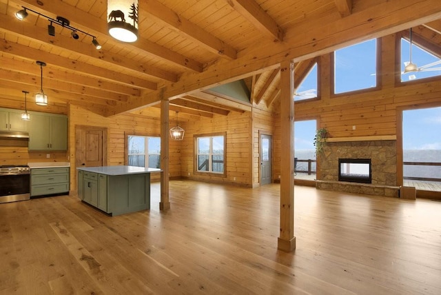 kitchen featuring a center island, wooden walls, stainless steel range oven, and green cabinets