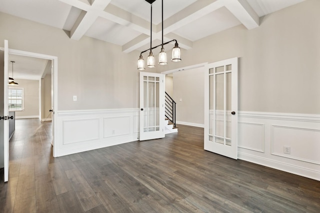 unfurnished dining area with beamed ceiling, dark wood-type flooring, and french doors