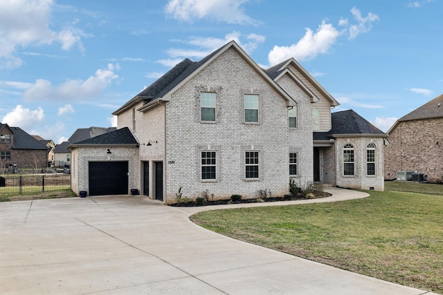 view of front of home featuring a garage, central AC, and a front lawn