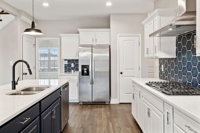 kitchen featuring white cabinets, appliances with stainless steel finishes, sink, and wall chimney range hood