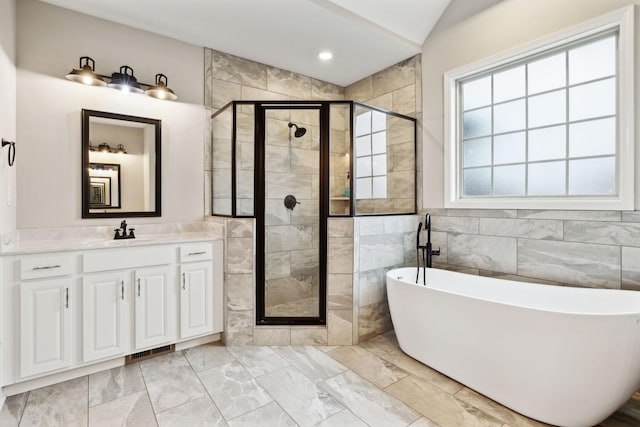 bathroom featuring vanity, lofted ceiling, shower with separate bathtub, and tile walls