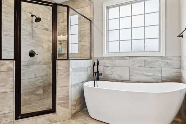 bathroom featuring separate shower and tub and tile walls