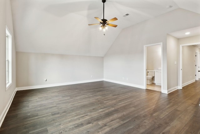 additional living space with ceiling fan, plenty of natural light, dark hardwood / wood-style flooring, and vaulted ceiling