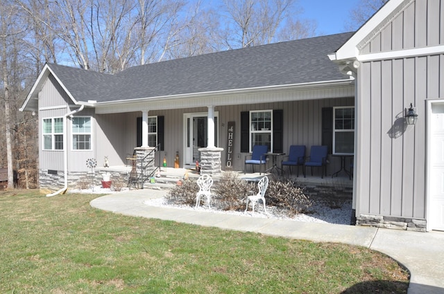 exterior space with roof with shingles, covered porch, board and batten siding, a front yard, and crawl space